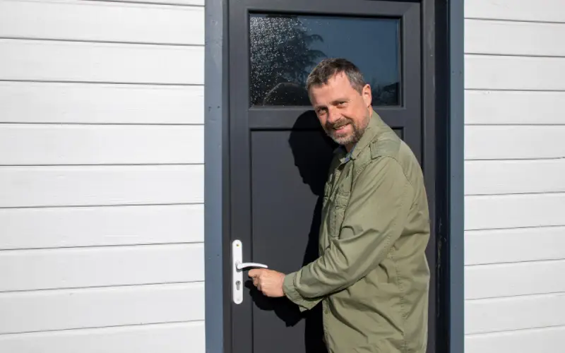 Locked Out of Your House,A man in a green jacket opening a door